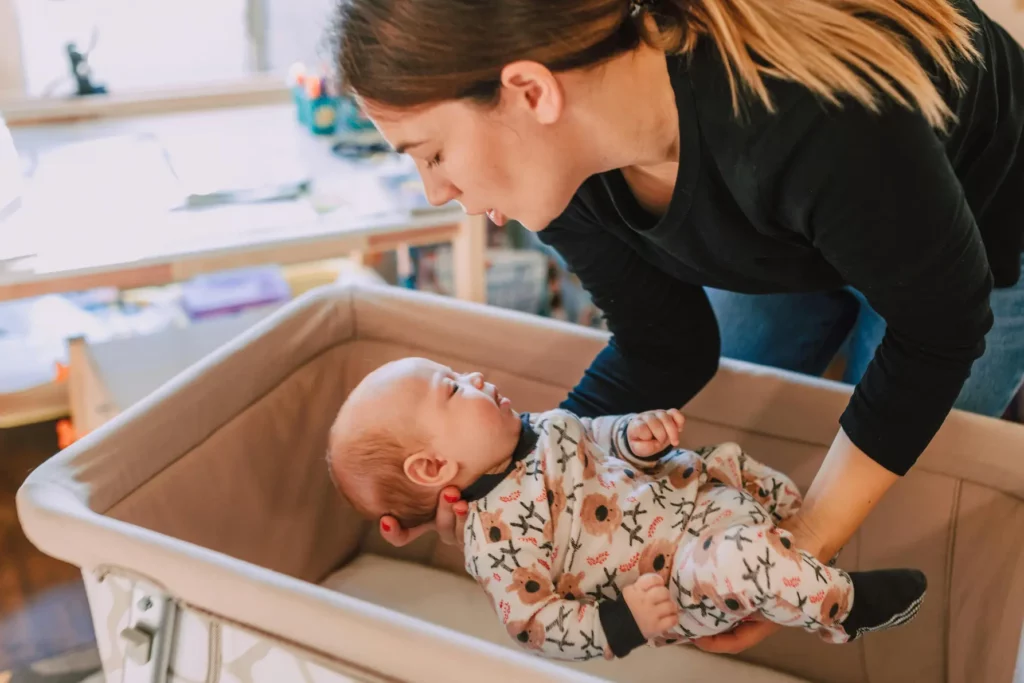Jeune femme couchant délicatement un bébé